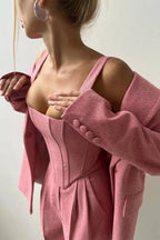 Ensemble femme trois pièces : haut ajusté en coton, jupe élégante et blazer moderne.