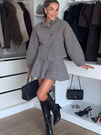 Ensemble gris femme avec jupe courte et veste longue à manches, en tissu léger.