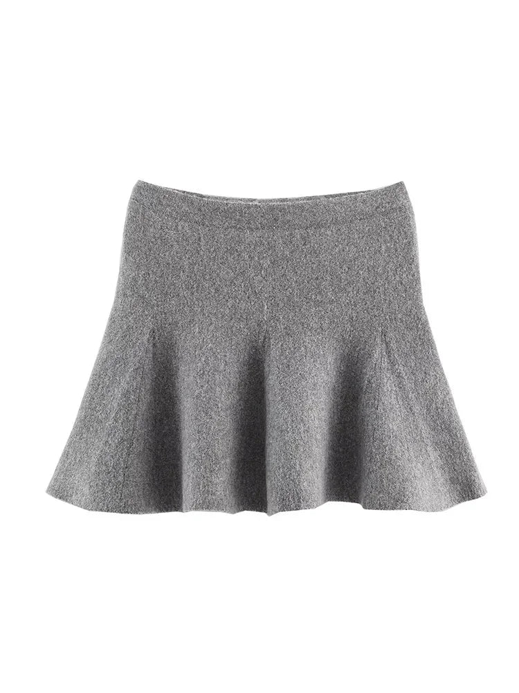 Ensemble gris femme avec jupe courte et veste longue cintrée à manches longues.