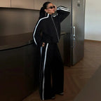 Ensemble de sport femme, comprenant une veste zippée et un pantalon large, en blanc et en tissu respirant.