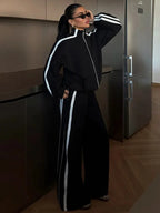 Ensemble de sport femme blanc, comprenant une veste zippée et un pantalon large en tissu respirant.