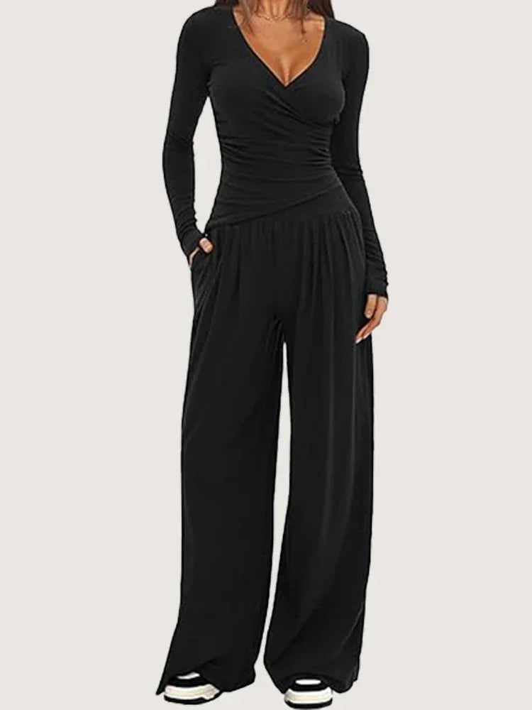 Ensemble sportswear femme noir, composé d'un pantalon ample et d'un haut à manches longues en tissu respirant.
