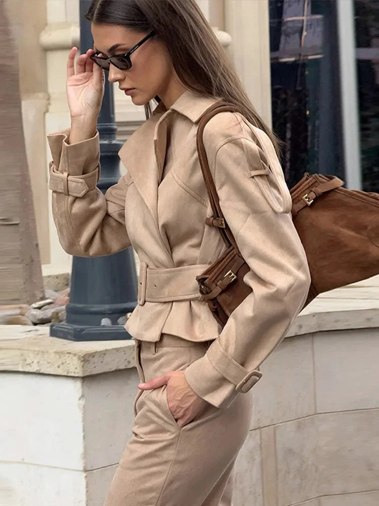 Ensemble femme en tissu élastique, comprenant une veste cintrée et un pantalon marron avec ceinture ajustable.