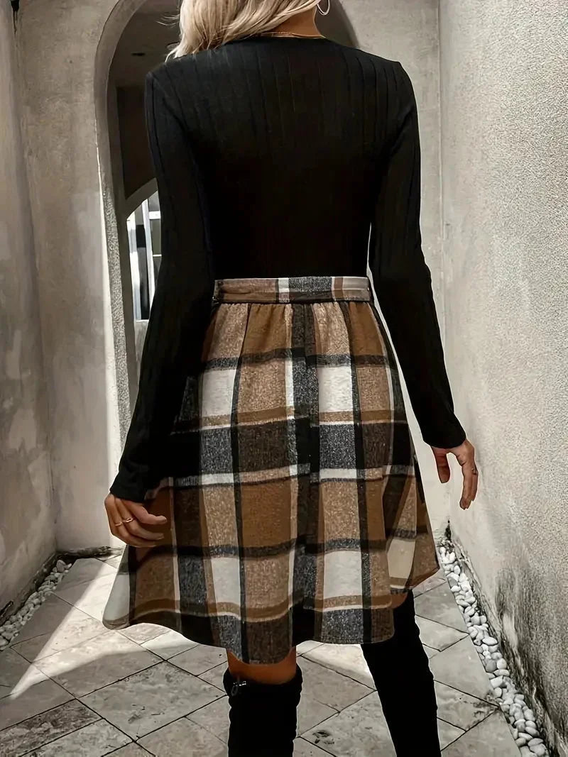 Haut noir ajusté à manches longues, associé à une jupe évasée à motifs à carreaux, en tissu doux et confortable.