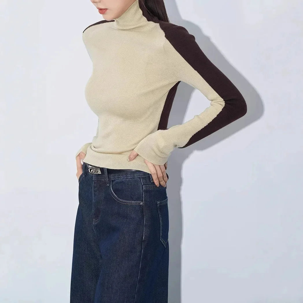 Damenoberteil mit hohem Kragen, kontrastierenden Ärmeln und weichem Material für angenehmen Tragekomfort.