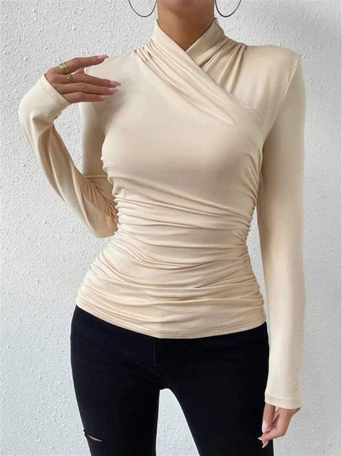 Haut croisé drapé à manches longues pour femme en beige, avec une silhouette élégante et un tissu doux.