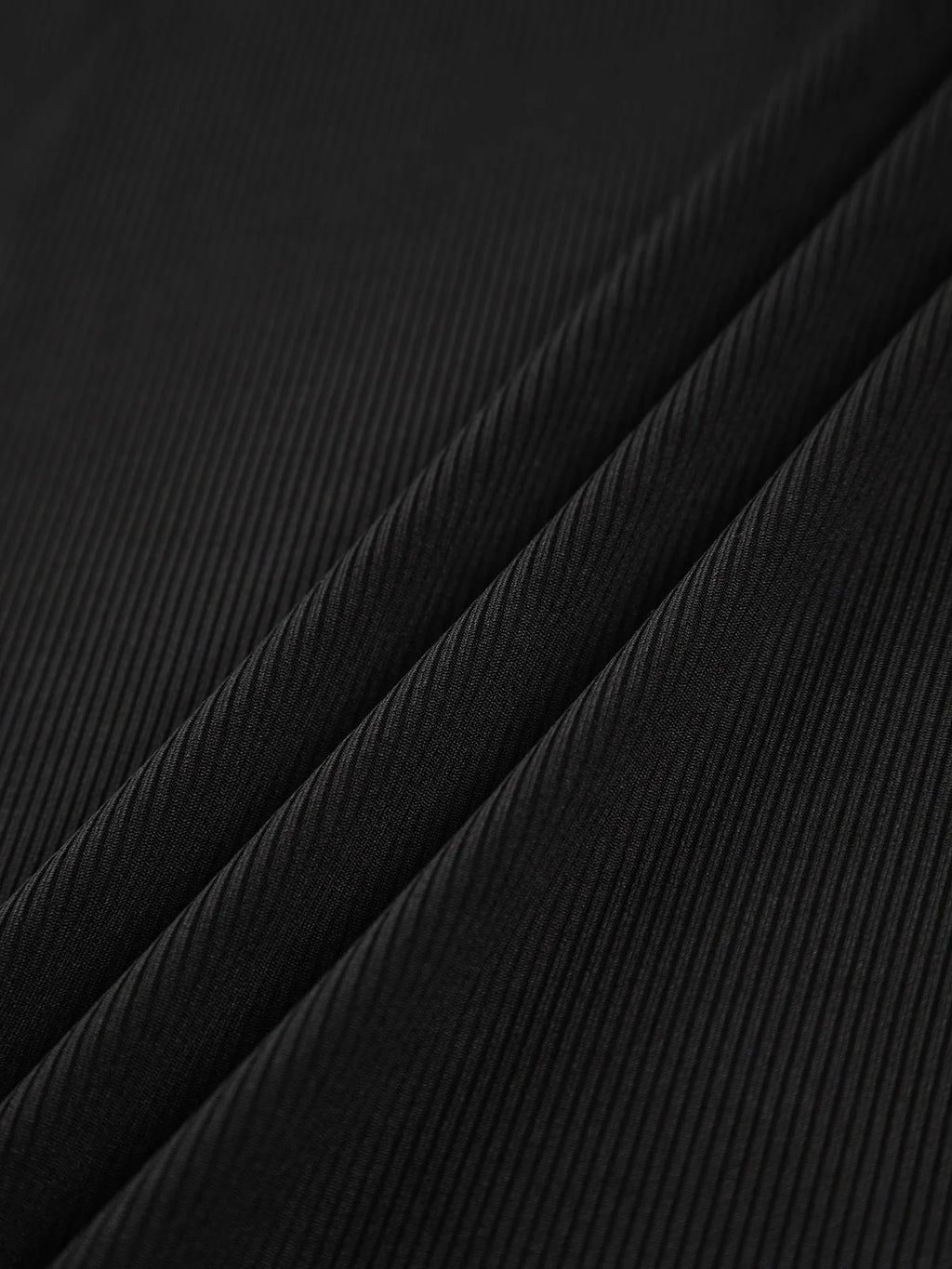 Haut femme asymétrique noir à col montant et découpe, en tissu doux et respirant.