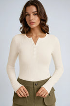 Haut femme blanc à manches longues, cintré, avec boutons sur le devant. Idéal pour un look décontracté.