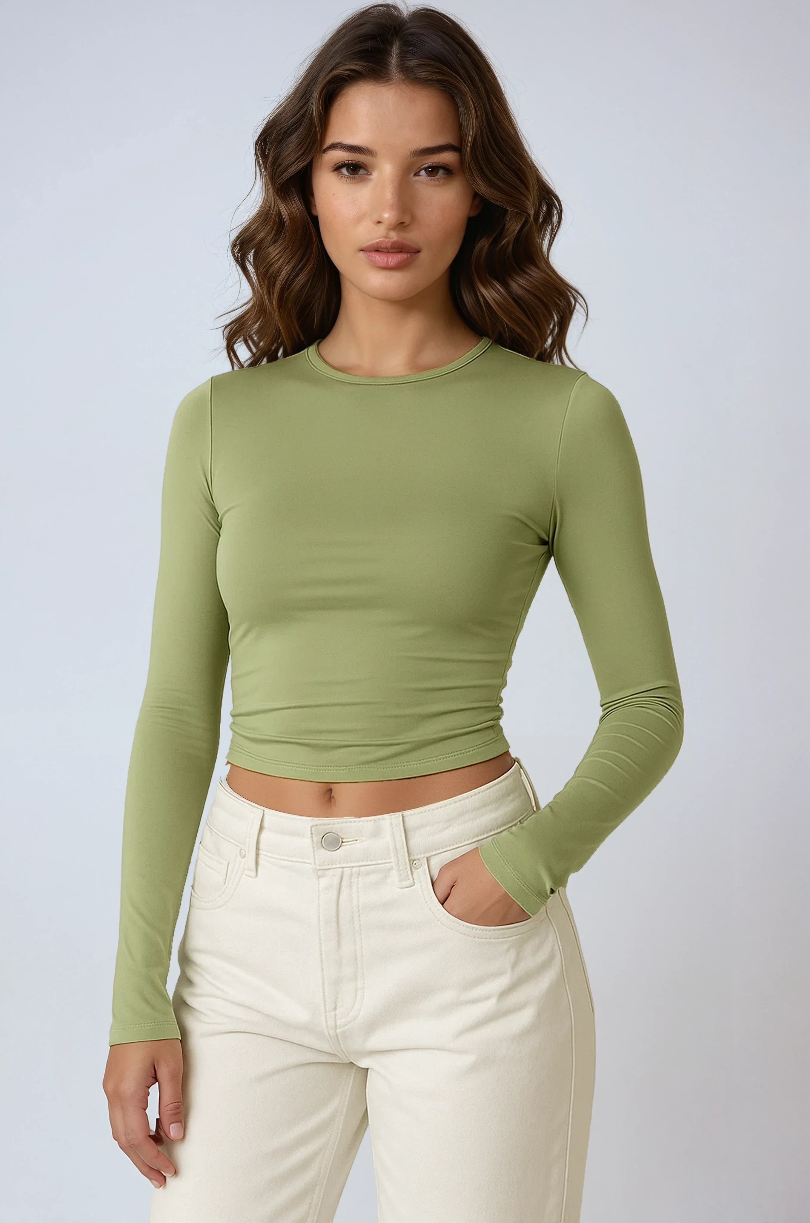 Haut femme vert clair à manches longues, en matière extensible, coupe ajustée et design simple.