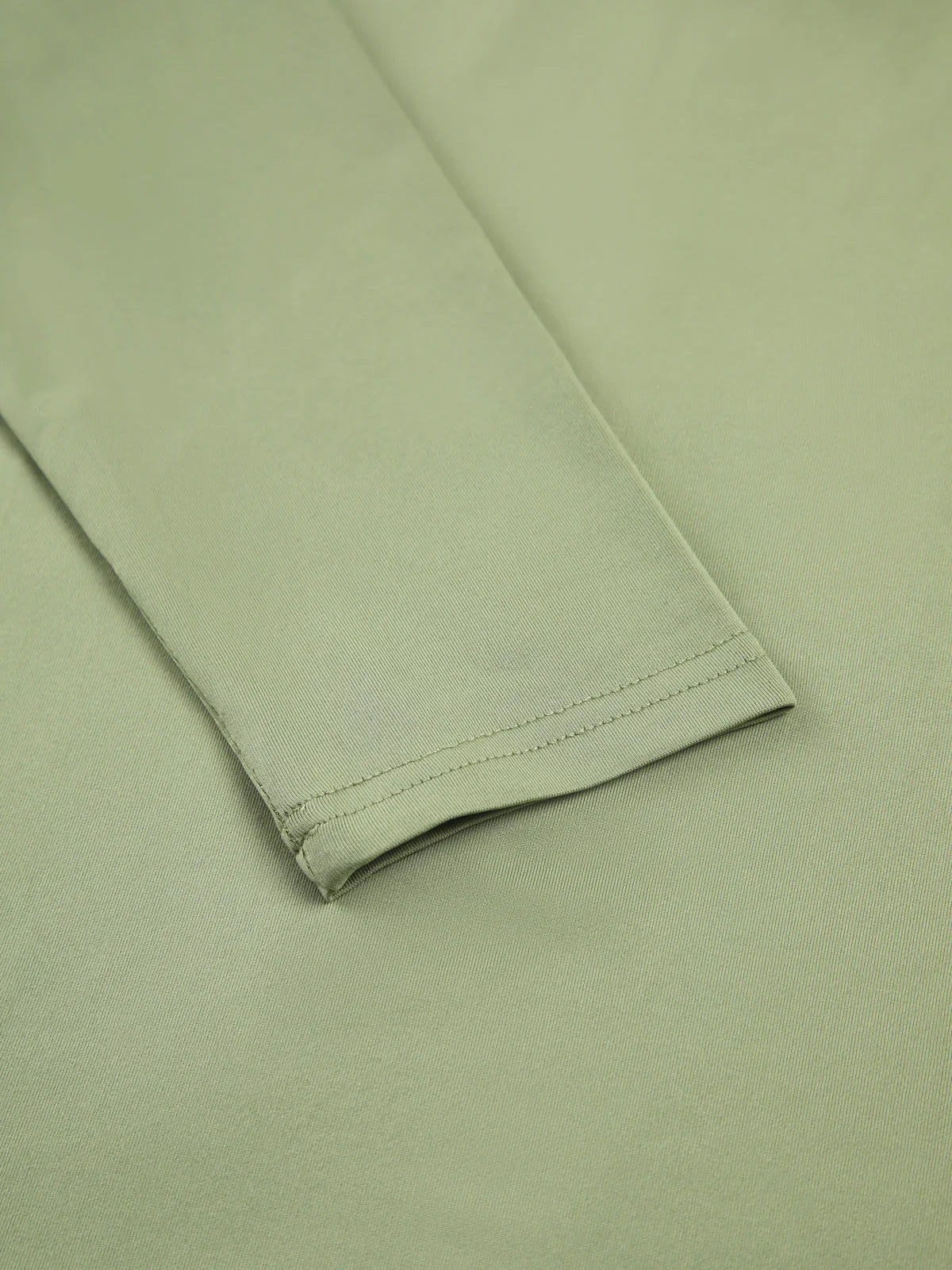 Haut femme verte clair à manches longues, en tissu extensible, coupe ajustée pour un bon confort.