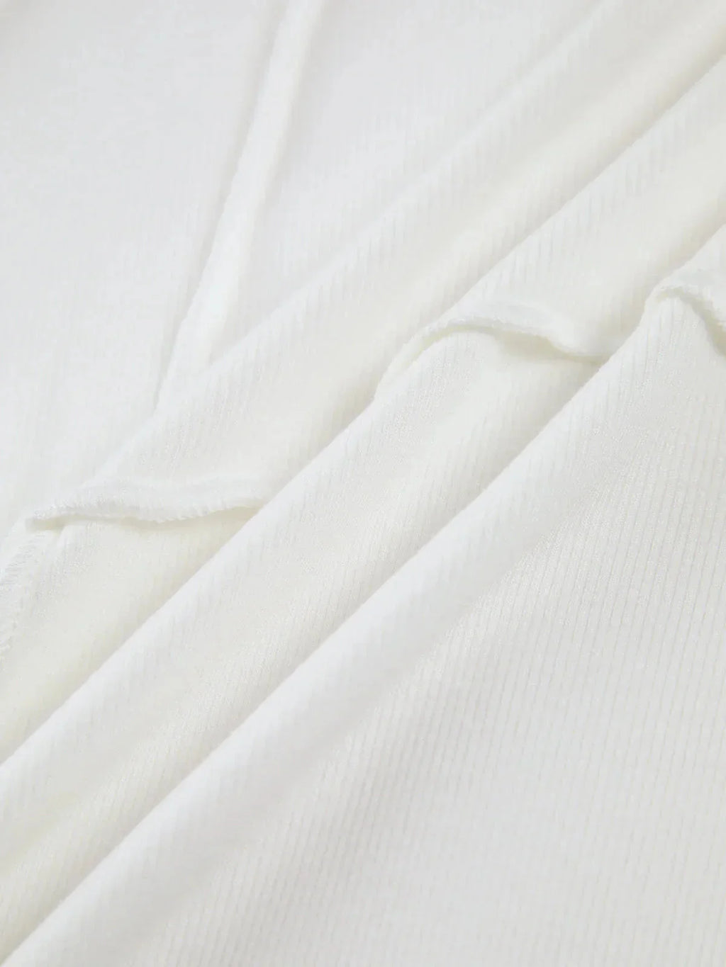 Haut à manches longues femme en blanc, avec coutures détaillées et coupe moderne pour un usage quotidien.