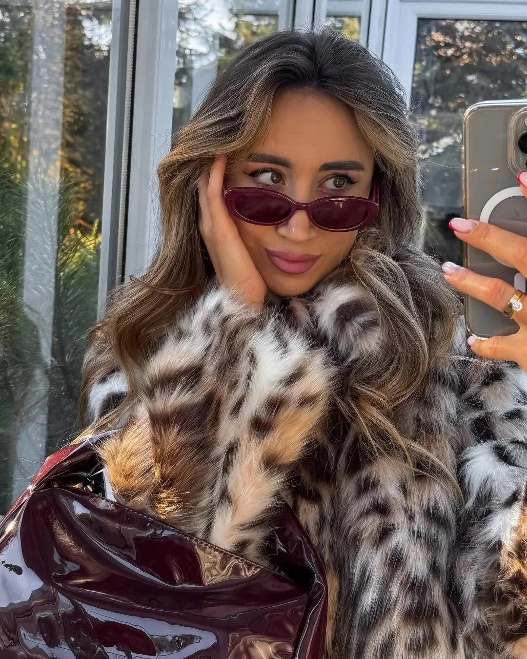 Manteau ample en fausse fourrure marron à motif animal, manches longues et capuche.