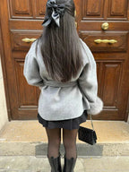 Manteau ceinturé femme gris, manches en plush, poches latérales, coupe élégante.