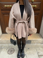 Manteau ceinturé beige pour femme, en plush, avec manches longues et silhouette élégante.