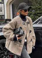 Manteau beige femme en matériau chaud, avec fermeture décorative et coupe classique, adapté pour les jours froids.