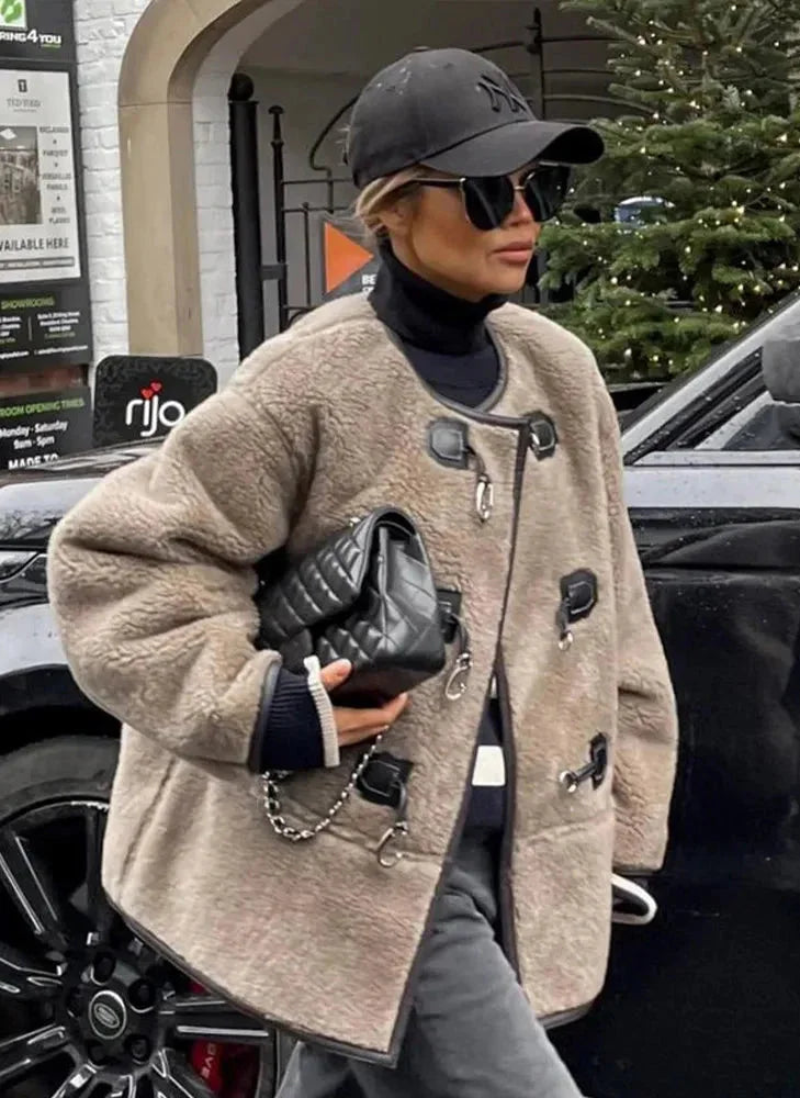 Manteau beige femme en matériau chaud, avec fermeture décorative et coupe classique, adapté pour les jours froids.