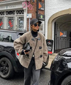 Manteau beige pour femme, coupe classique, avec fermeture décorative, en matériau doux, adapté aux journées froides.