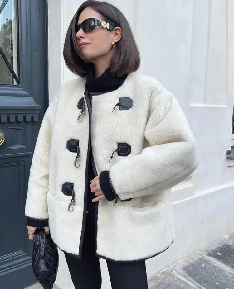 Manteau chaud femme beige avec fermeture décorative et silhouette élégante.