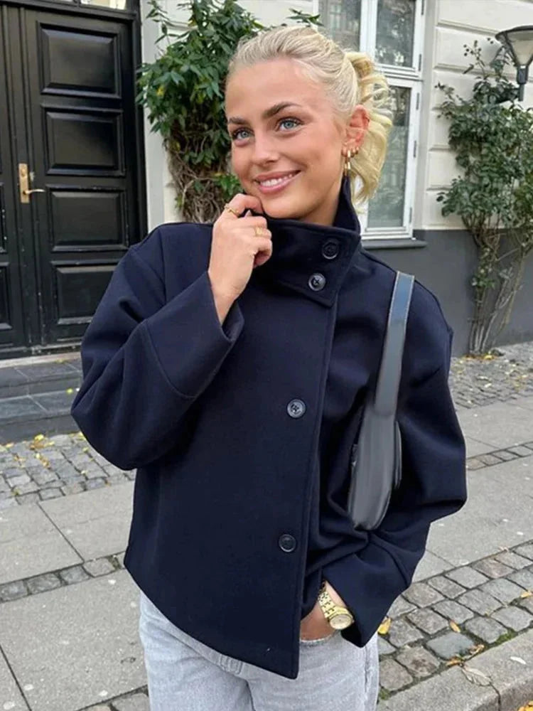 Manteau court femme bleu foncé avec boutons et col montant, en tissu chaud, adapté pour l'automne.