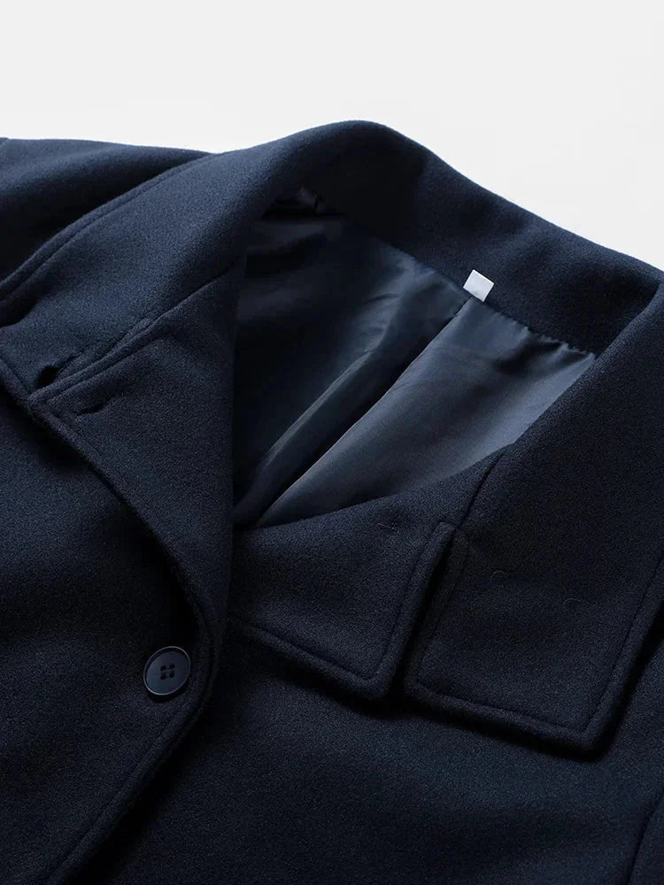 Manteau court femme bleu foncé, avec boutons et col montant pour un style classique et confortable.