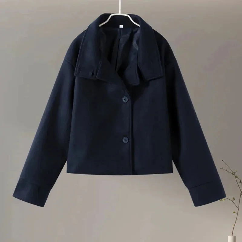 Manteau court femme gris avec boutons et col montant, design moderne et élégant.