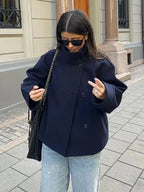 Manteau court femme bleu foncé, avec boutons et col montant pour plus de chaleur et de style.