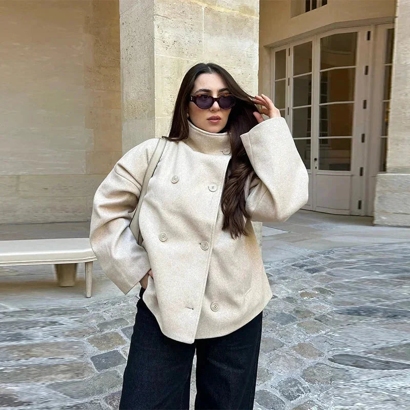 Manteau court femme bleu foncé avec boutons et col montant, en tissu doux, adapté pour la mi-saison.