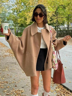 Manteau court oversize beige pour femme avec boutons, en tissu léger et au design décontracté.