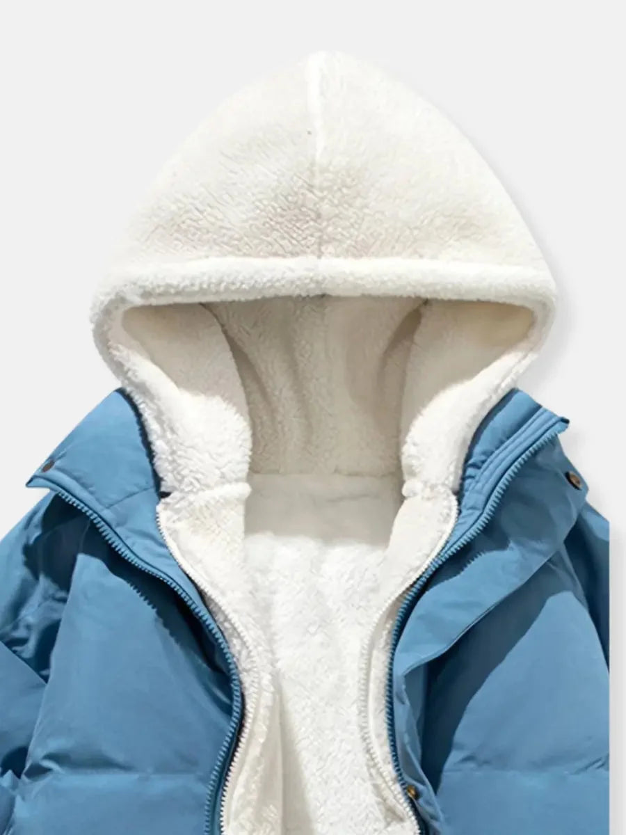 Dunkelblaue Winterjacke für Frauen mit Kapuze, weicher Fütterung und praktischem Reißverschluss für sicheres Tragen.