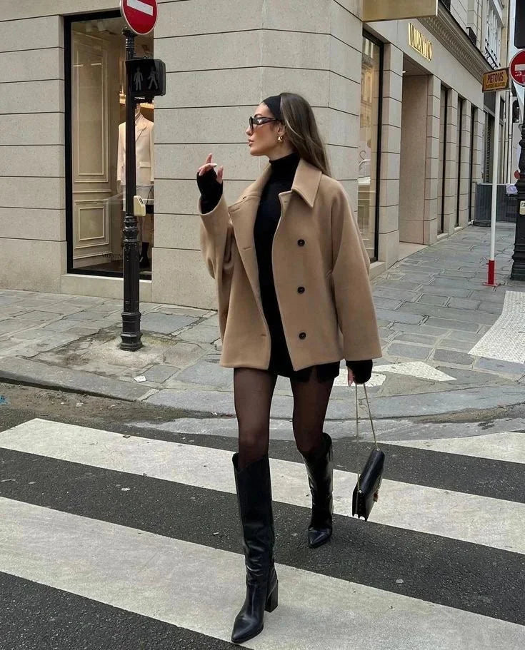 Manteau femme ample noir avec grands revers, fermeture à boutons et mélange de laine pour un confort optimal.