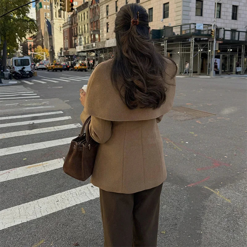 Manteau femme camel avec cape, taille ajustée, conçu pour les looks d'automne.