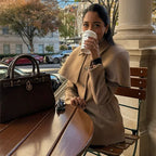 Manteau femme camel avec cape intégrée et taille ajustable, en tissu doux et chaud.