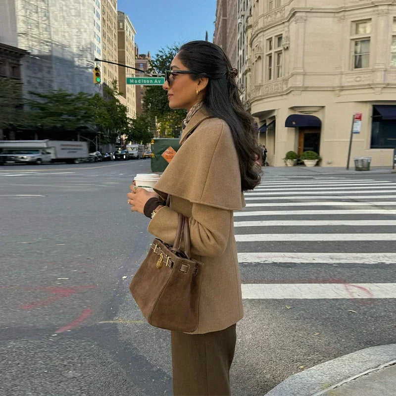 Manteau femme camel avec cape, taille ajustée, en tissu doux pour un confort élégant.