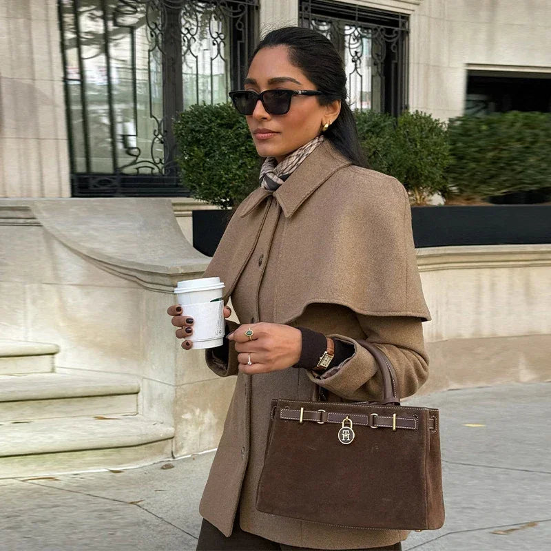 Manteau femme camel avec taille ajustée et cape intégrée, en tissu doux.