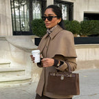 Manteau femme camel avec taille ajustée et cape intégrée, en tissu doux.