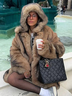 Manteau long marron pour femme, avec capuche et doublure pour plus de confort.