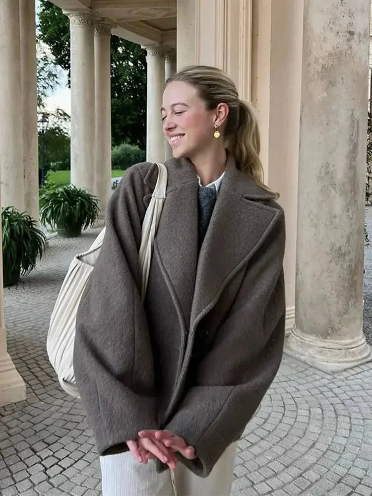 Manteau oversize marron pour femme avec boutons, en tissu doux et chaud, idéal pour les journées froides.