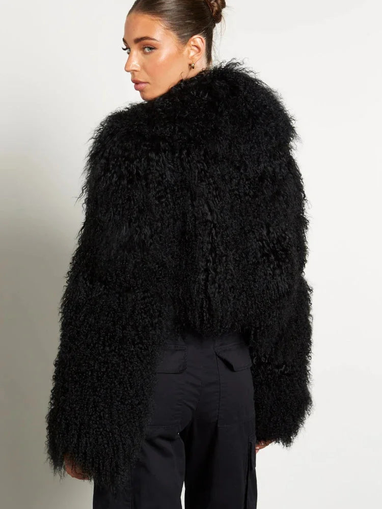 Manteau femme noir en peluche, manches longues, coupe moderne, adapté pour les journées fraîches.