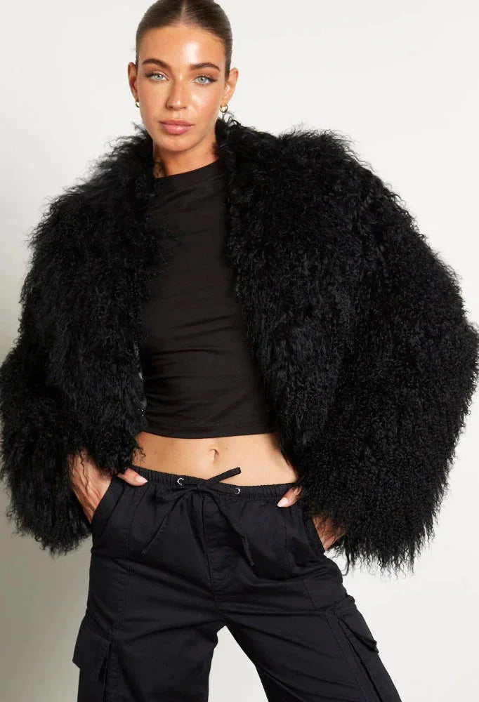 Manteau femme noir en tissu peluche, manches longues, coupe décontractée, adapté pour les journées fraîches.