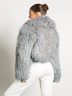 Manteau femme en peluche gris, manches longues, coupe moderne et douce au toucher.