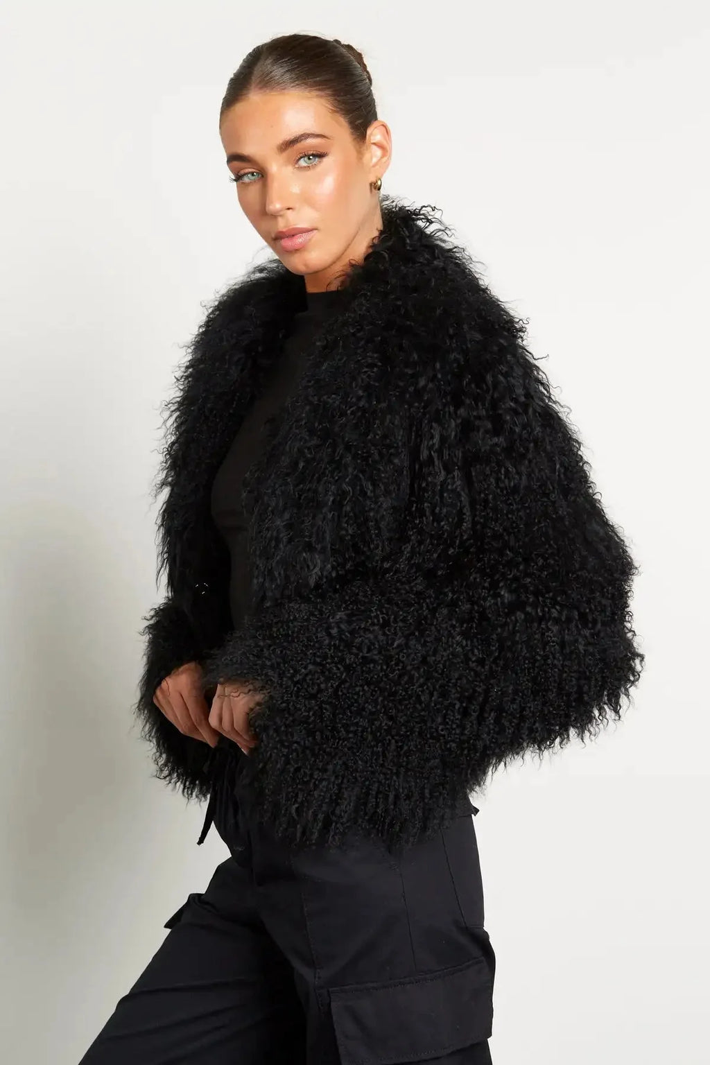 Manteau femme noir en peluche, manches longues, design simple et chaud pour les journées froides.