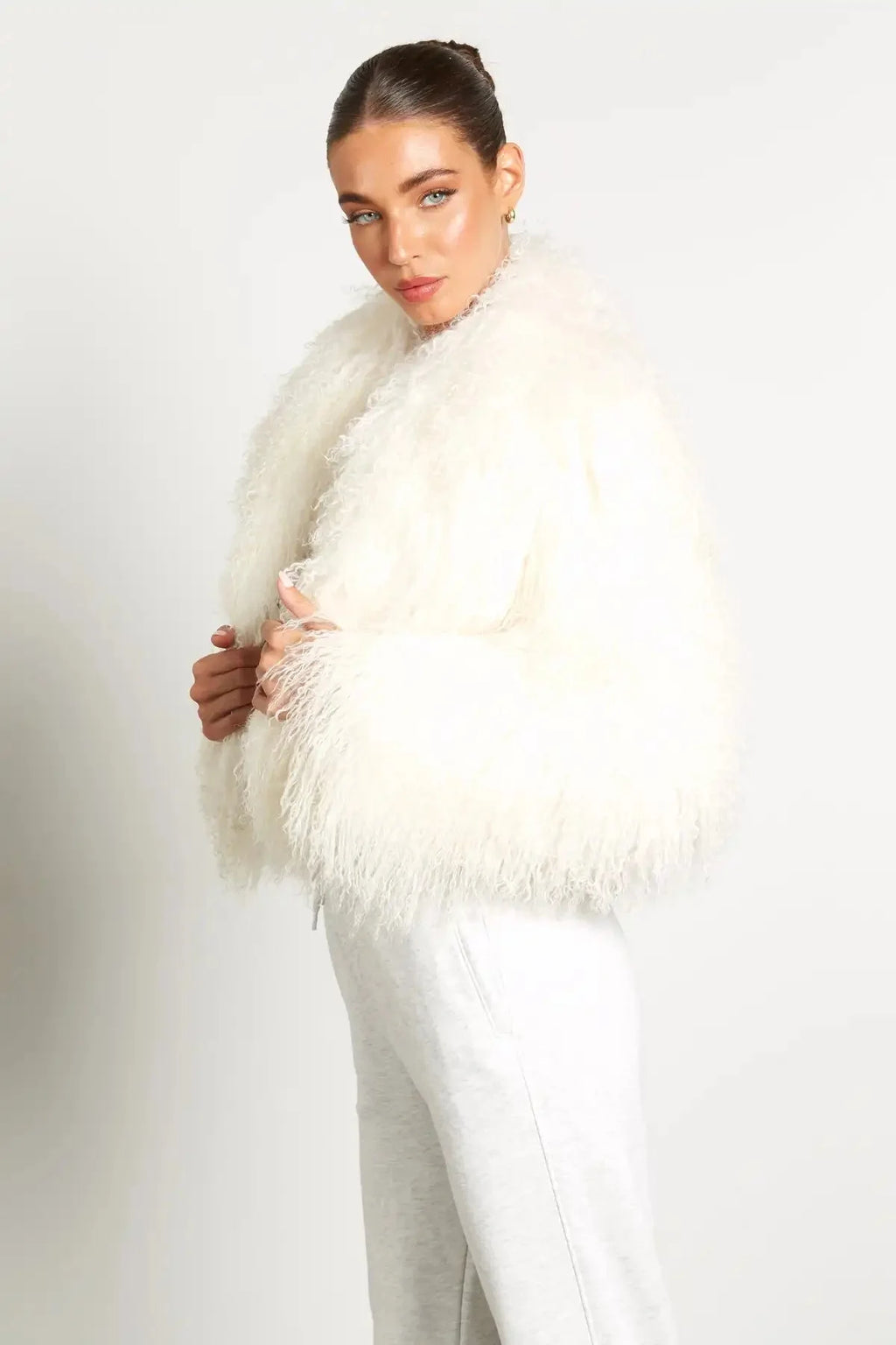 Manteau femme en peluche blanche, à manches longues et coupe confortable, adapté pour les journées froides.