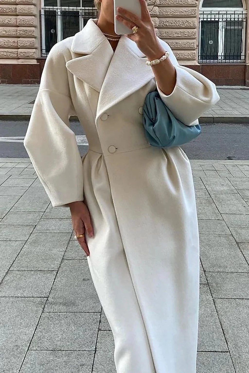 Manteau long für Frauen in Weiß, aus weichem Material mit breitem Kragen und minimalistischer Silhouette.