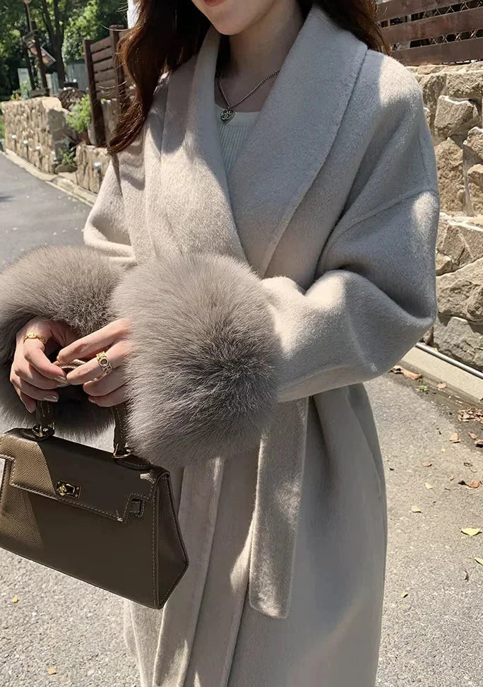 Manteau long taupe ceinturé, coupe ajustée, manches en fausse fourrure, en mélange de laine doux.