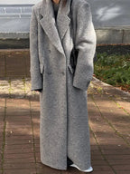 Manteau long femme kaki à rayures modernes, coupe élégante avec détails contemporains.