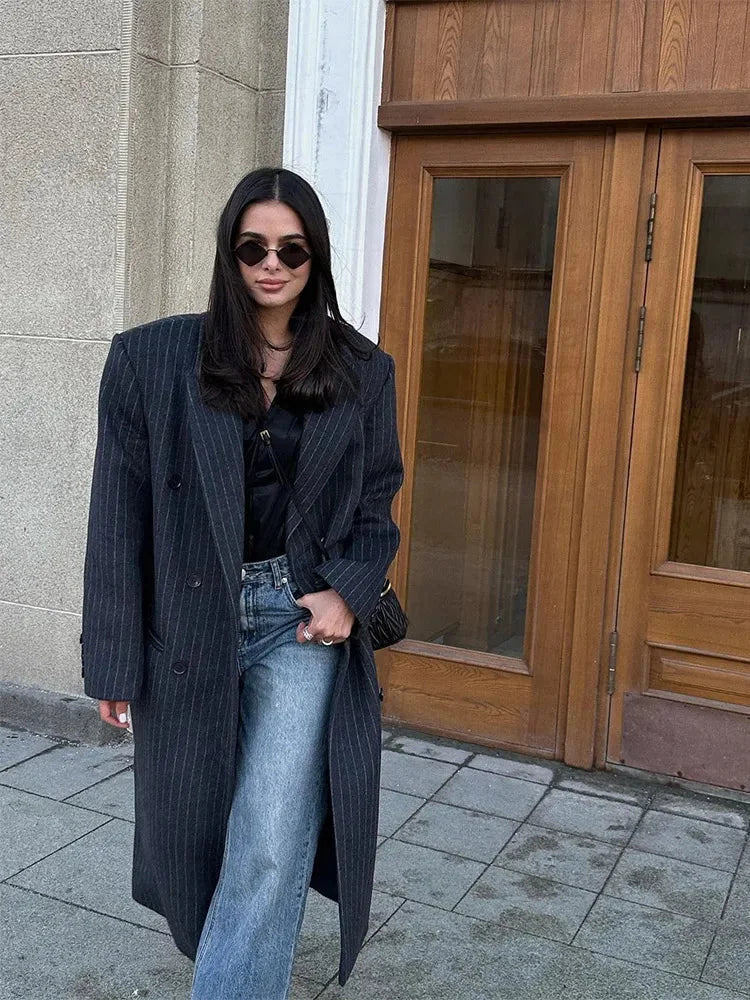 Manteau long femme à rayures modernes, en tissu doux, avec une coupe élégante et des lignes contemporaines.
