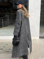 Grauer, langer Mantel für Damen mit langen Ärmeln, aus weich fließendem Material und modernem Schnitt für stilvolle Wärme.