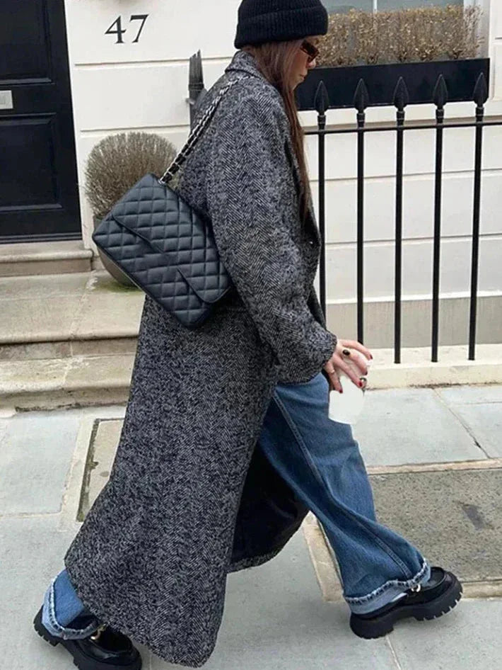 Manteau langes, graues Damenmodell mit langen Ärmeln, aus weichem Material, zeitloses Design mit praktischen Taschen.