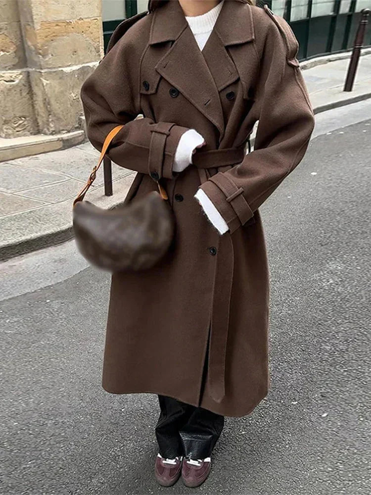 Manteau mi-long noir pour femme, ceinture à la taille, boutons sur le devant, design élégant et pratique.