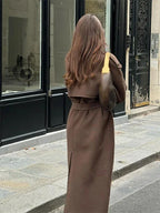 Manteau mi-long femme marron avec ceinture à la taille et boutons décoratifs.